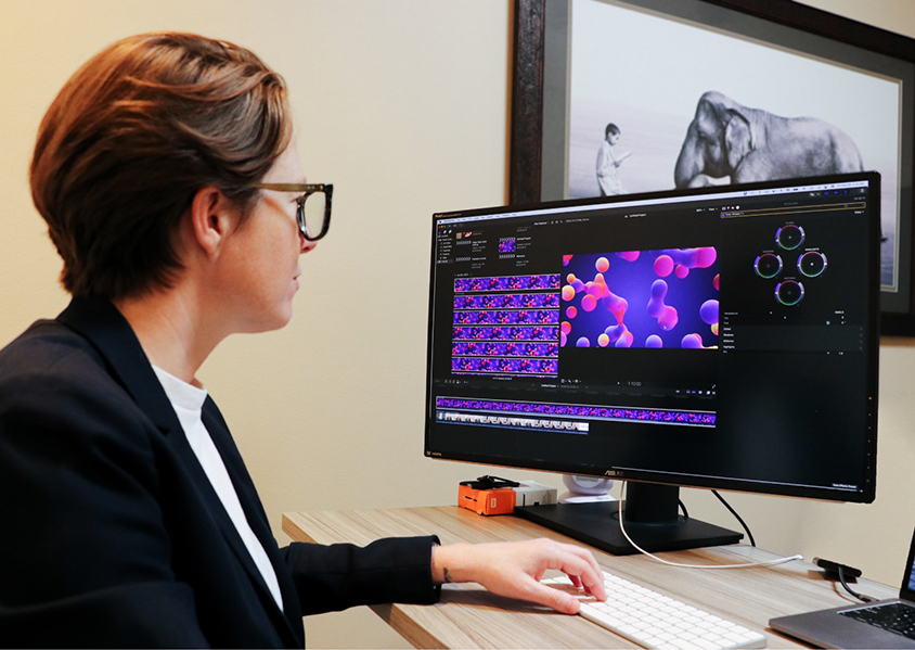 Photo of woman editing video footage on a computer